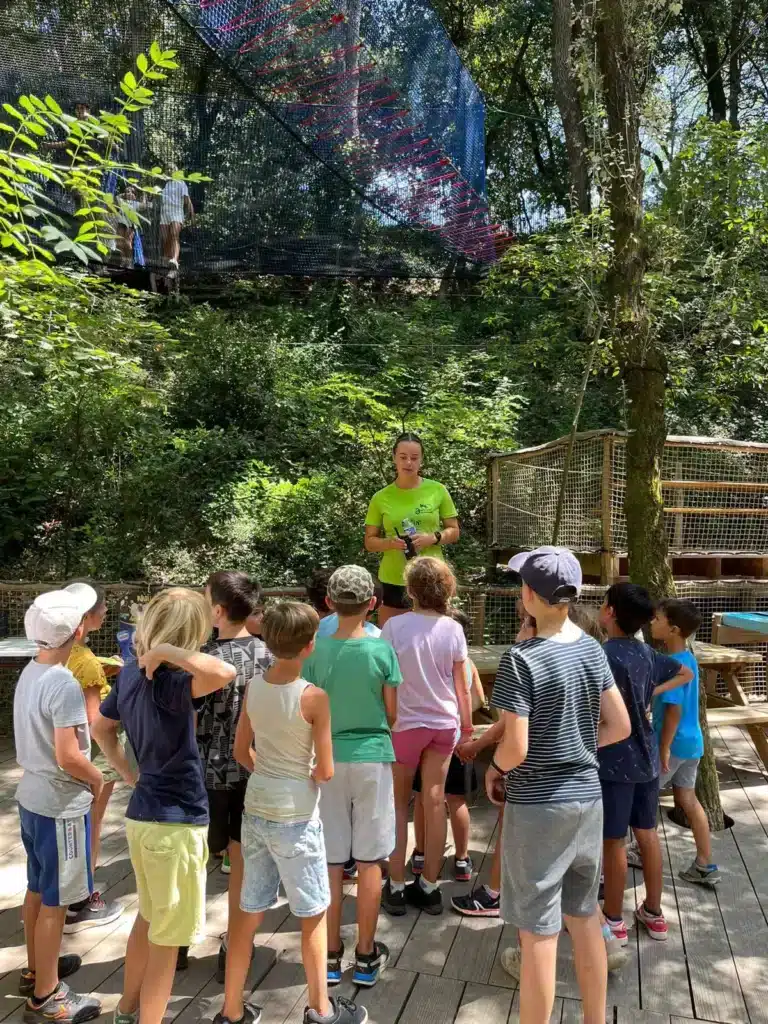 Un groupe d'enfants écoutant un animateur au Parc Casse-Noisette, lors d'une présentation avant de participer aux activités ludiques en pleine nature. ​​







